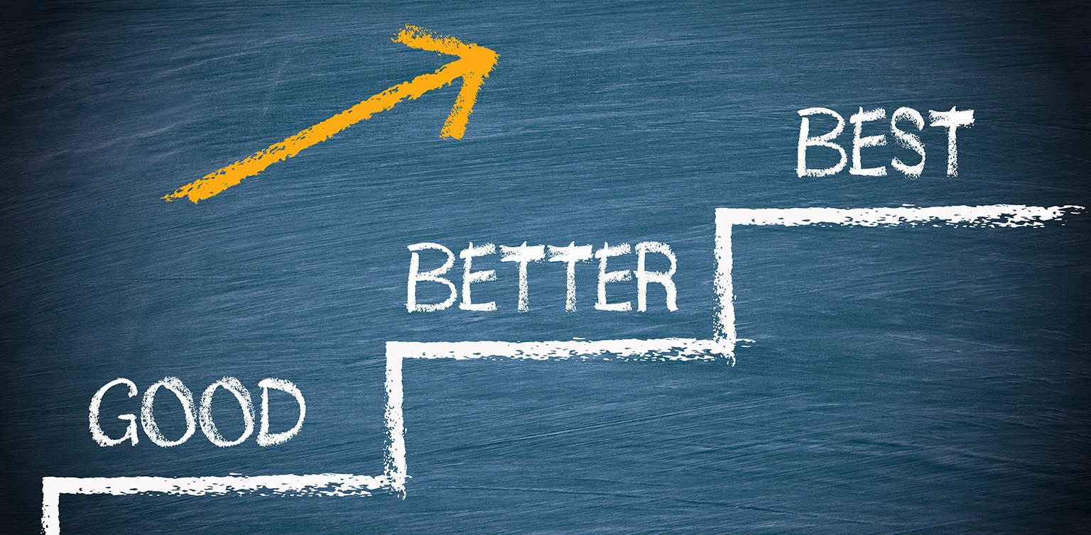 A blackboard with a white chalk drawing of steps with the words good , better best and a yellow arrow above it